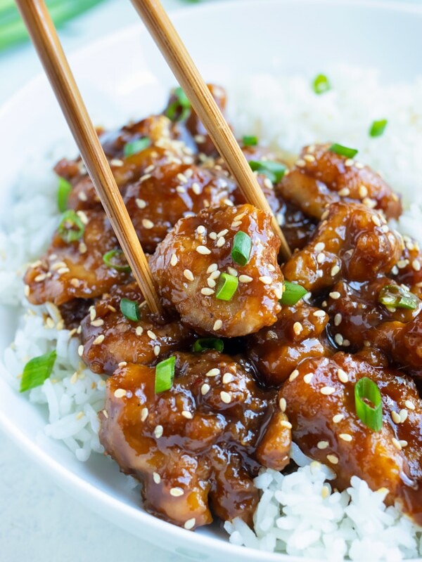 General Tsos Chicken is eaten with chopsticks and white rice.