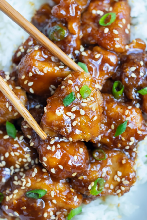 A serving of sweet and spicy General Tao Chicken is eaten with chopsticks.