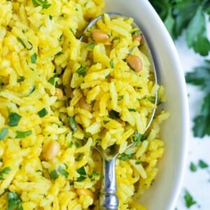 A bowl full of yellow rice is served for a gluten-free side dish.