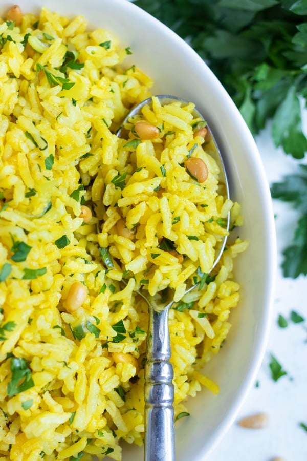 A bowl full of yellow rice is served for a gluten-free side dish.