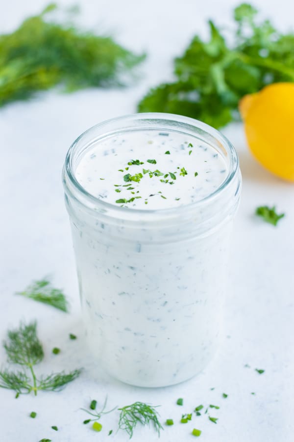 Easy homemade ranch dressing is stored in a glass jar.