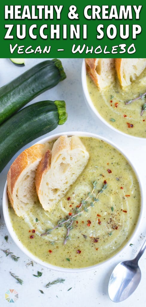 Two bowls of zucchini soup are set on the counter next to fresh zucchini.