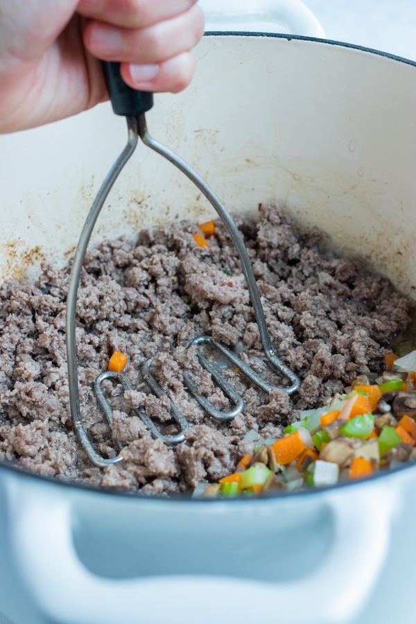 The ground beef is added to the pot and browned.