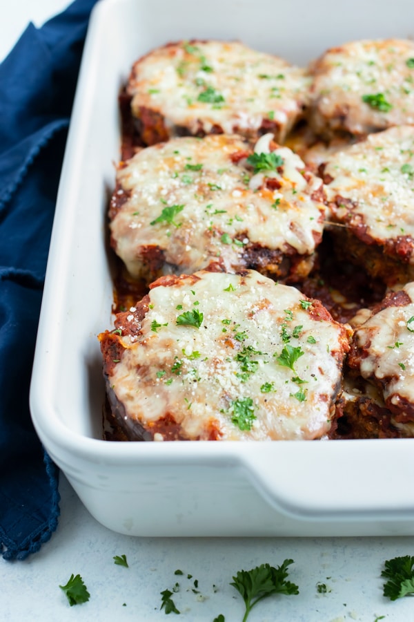 Crispy eggplant parmesan is shown in a baking dish.
