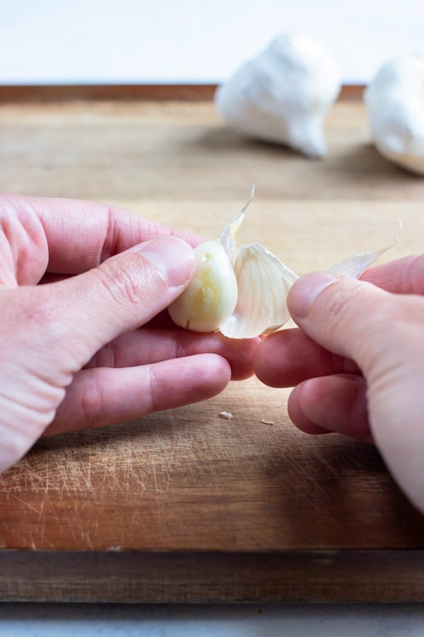 Garlic clove is peeled with your hands.