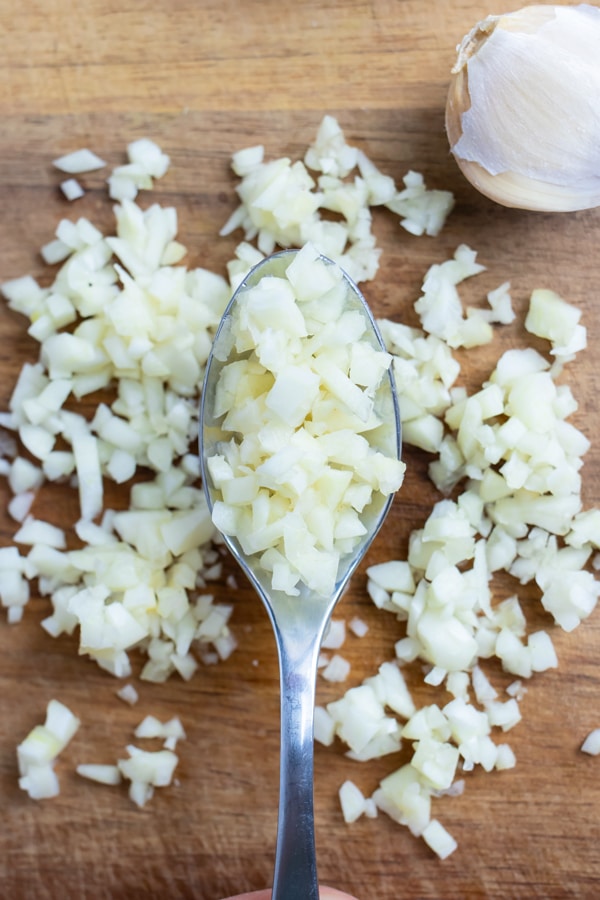 A spoon is used to hold the minced garlic.