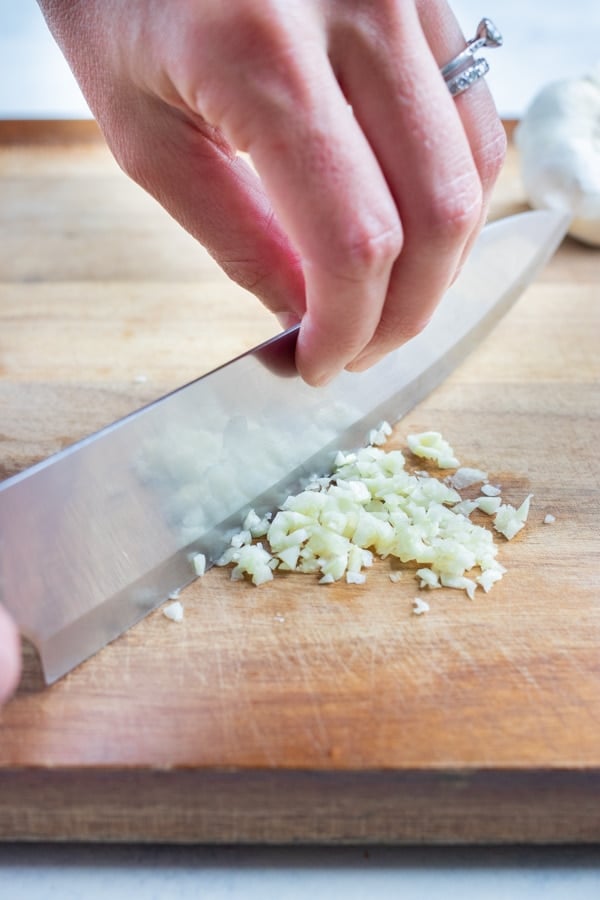 The garlic clove is then finely chopped with a chefs knife.