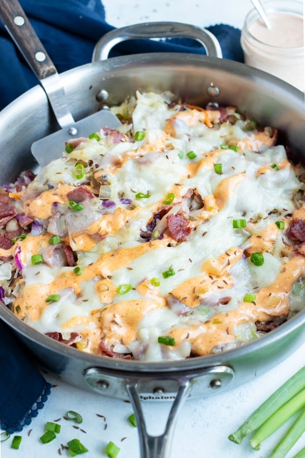 Reuben in a bowl is topped with homemade thousand island dressing.
