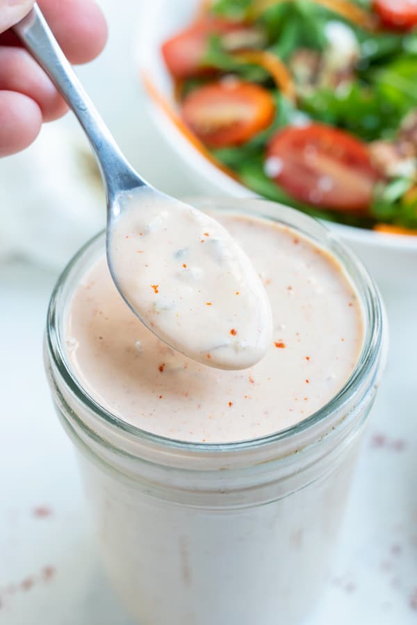 Homemade thousand island dressing is spooned from a mason jar.