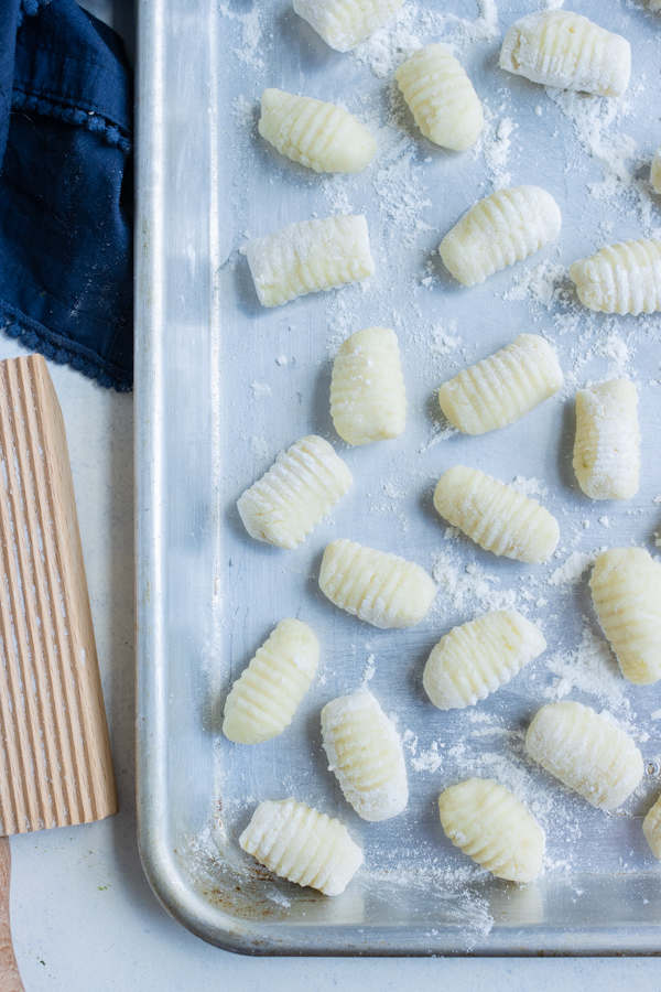 A baking sheet is used to hold the gnocchi before boiling.
