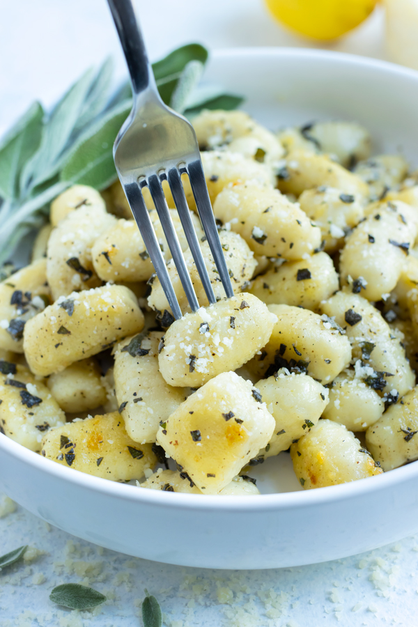 A fork is shown lifting up homemade gnocchi.