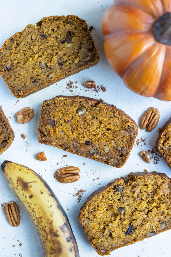 Slices of pumpkin banana bread are set on the counter.