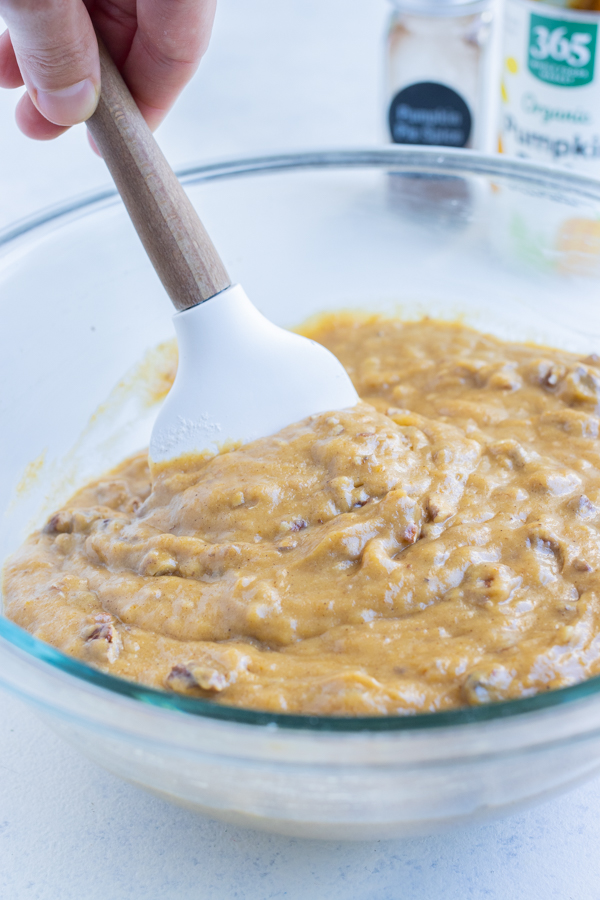 Wet and dry ingredients are mixed together with a spatula.
