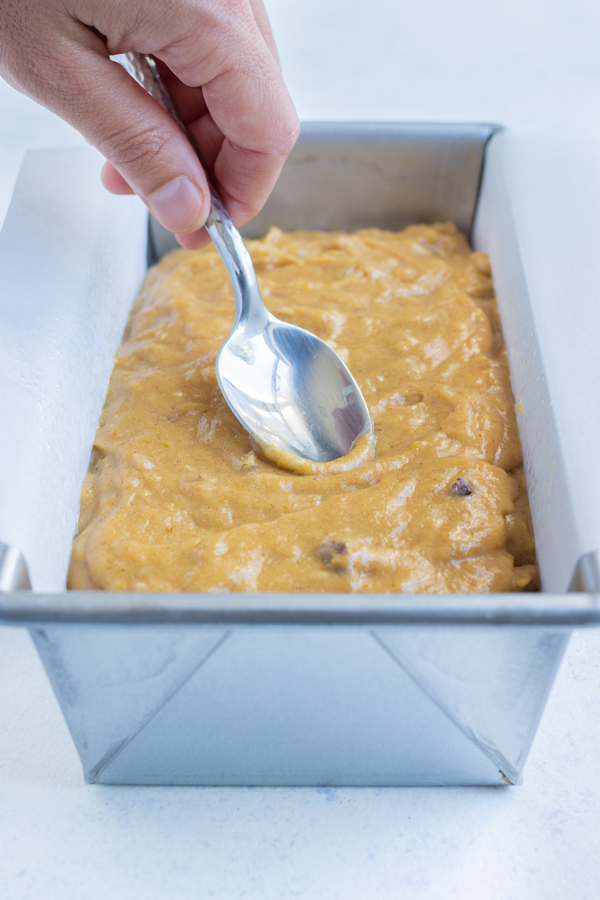 The pumpkin banana bread mixture is put into a loaf pan.