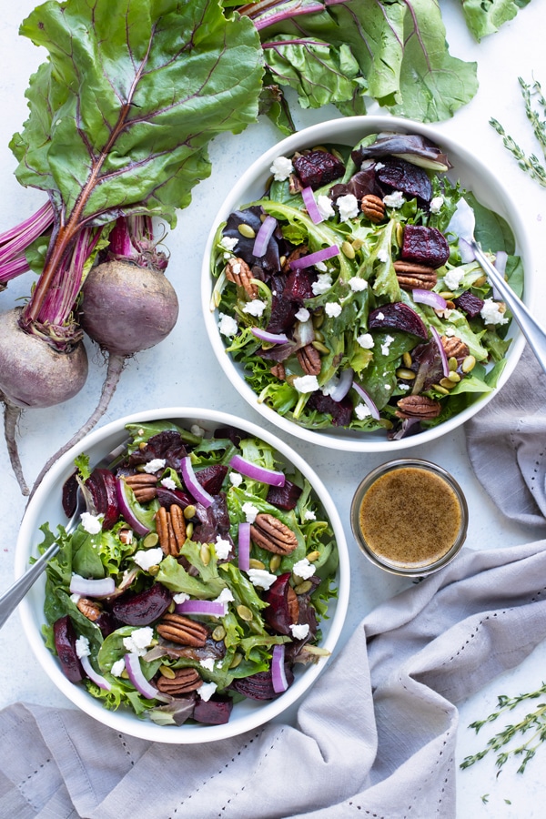 Two bowls of beet salad are served on the counter with homemade vinaigrette.