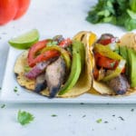 Corn tortillas are loaded with veggies and flavorful steak.