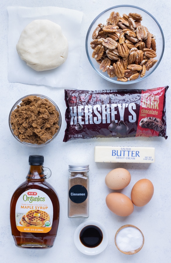 Pie dough, pecans, brown sugar, maple syrup, eggs, butter, and chocolate chips are the ingredients in this recipe.