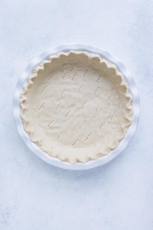 Pie dough is prepared in a pie dish.