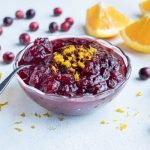 Cranberry and orange sauce is served from a glass bowl.