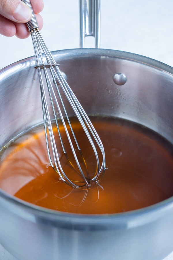 Maple syrup, orange juice, and water are combined on the stove.