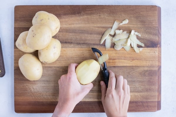 Potatoes are peeled with a vegetable peeler.