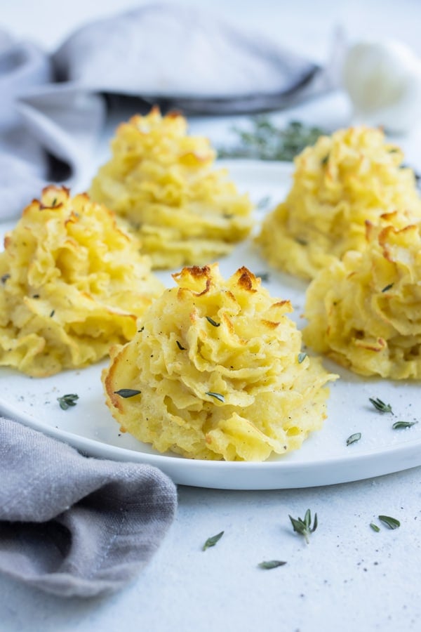 Golden duchess potatoes are served on a plate for a side.