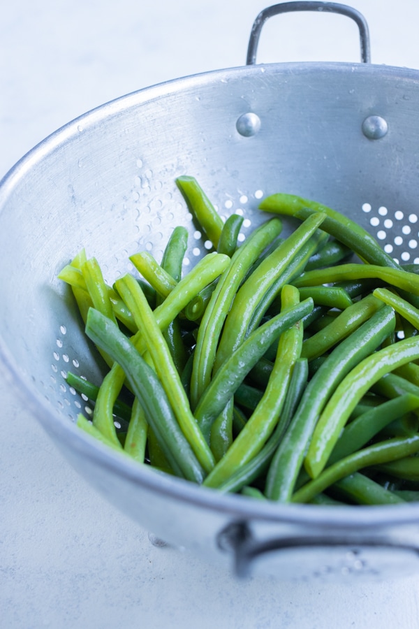 Boiled beans are drained using a colander.