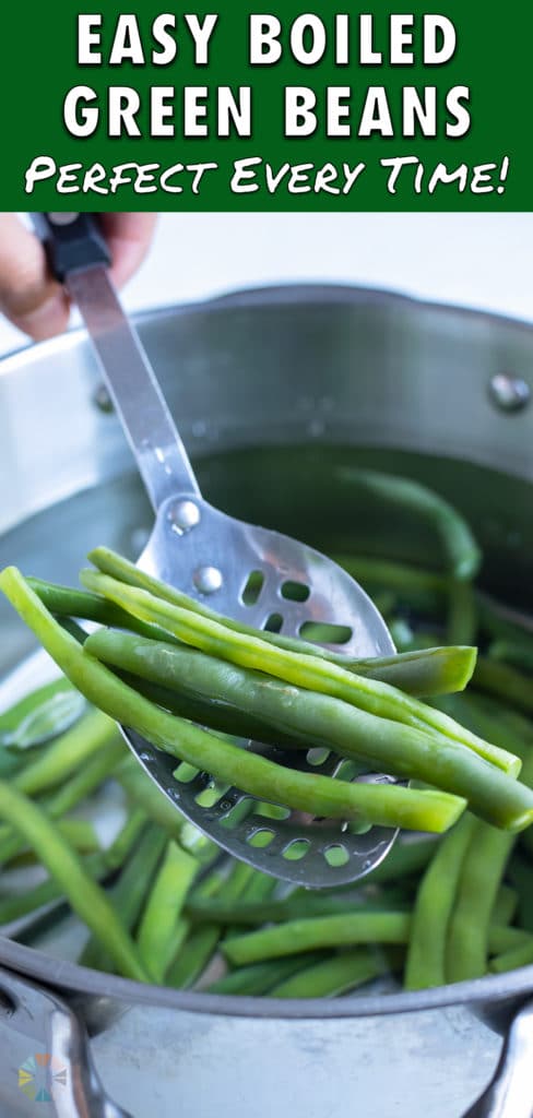 Green beans are boiled in a pot on the stove.