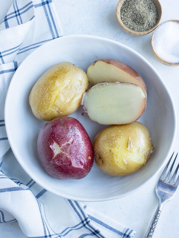 A bowl is used to hold red potatoes and golden potatoes that have been boiled.