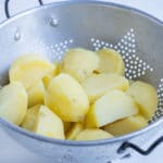 A colander is used to hold the diced, boiled potatoes.