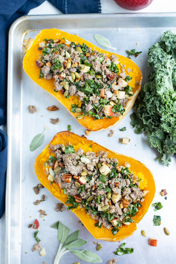 Two stuffed butternut squashes are shown side by side on the counter.