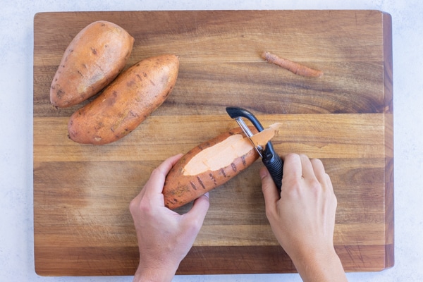Sweet potatoes are peeled one by one.