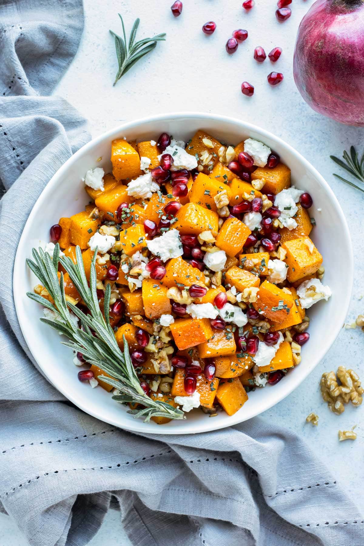 Butternut squash with goat cheese and pomegranate arils are served in a white bowl for the holidays.