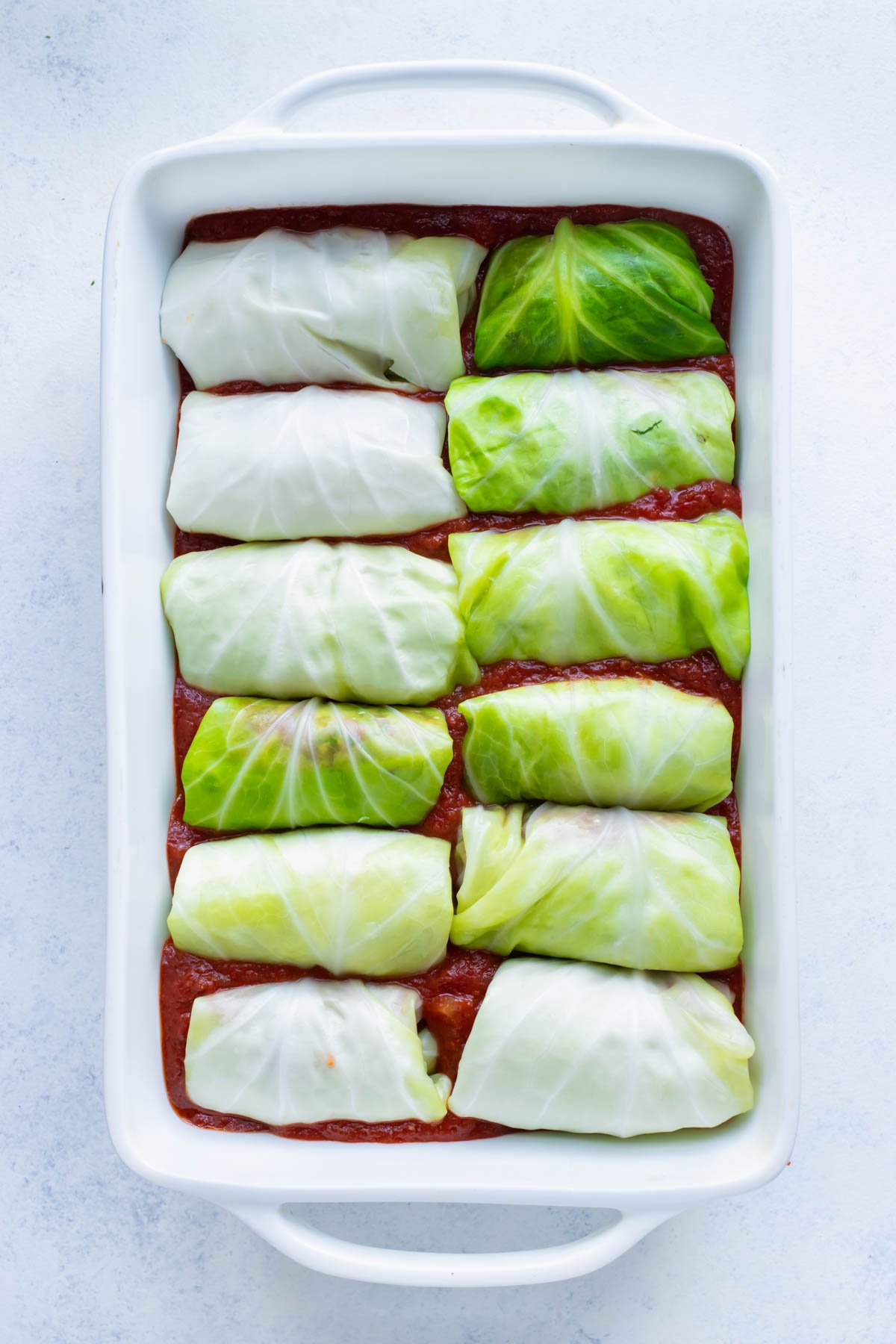 All cabbage rolls are placed seam down in the tomato sauce.