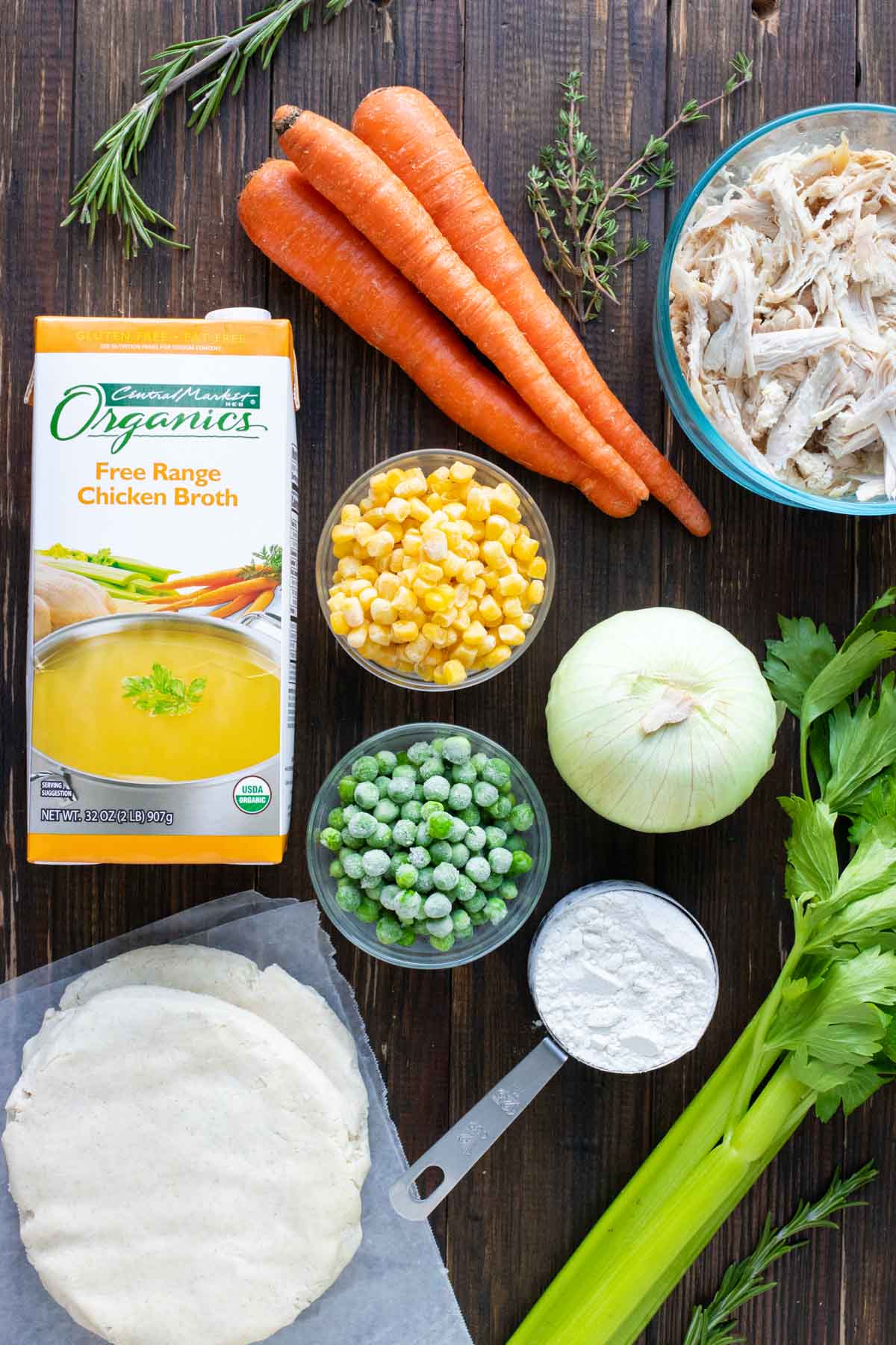 Carrots, corn, peas, celery, onion, pie crust, and shredded chicken as the ingredients for a chicken pot pie recipe.