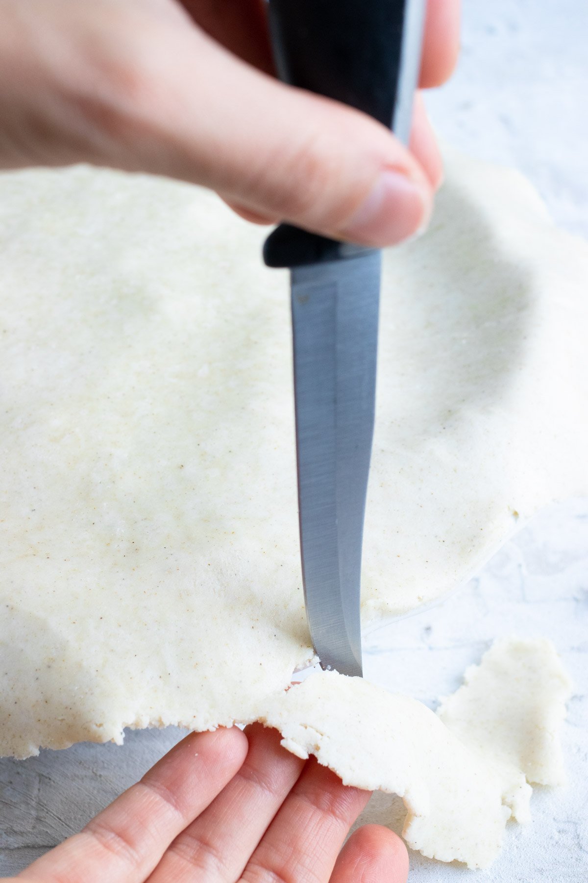 The edges of the pie crust are cut off.