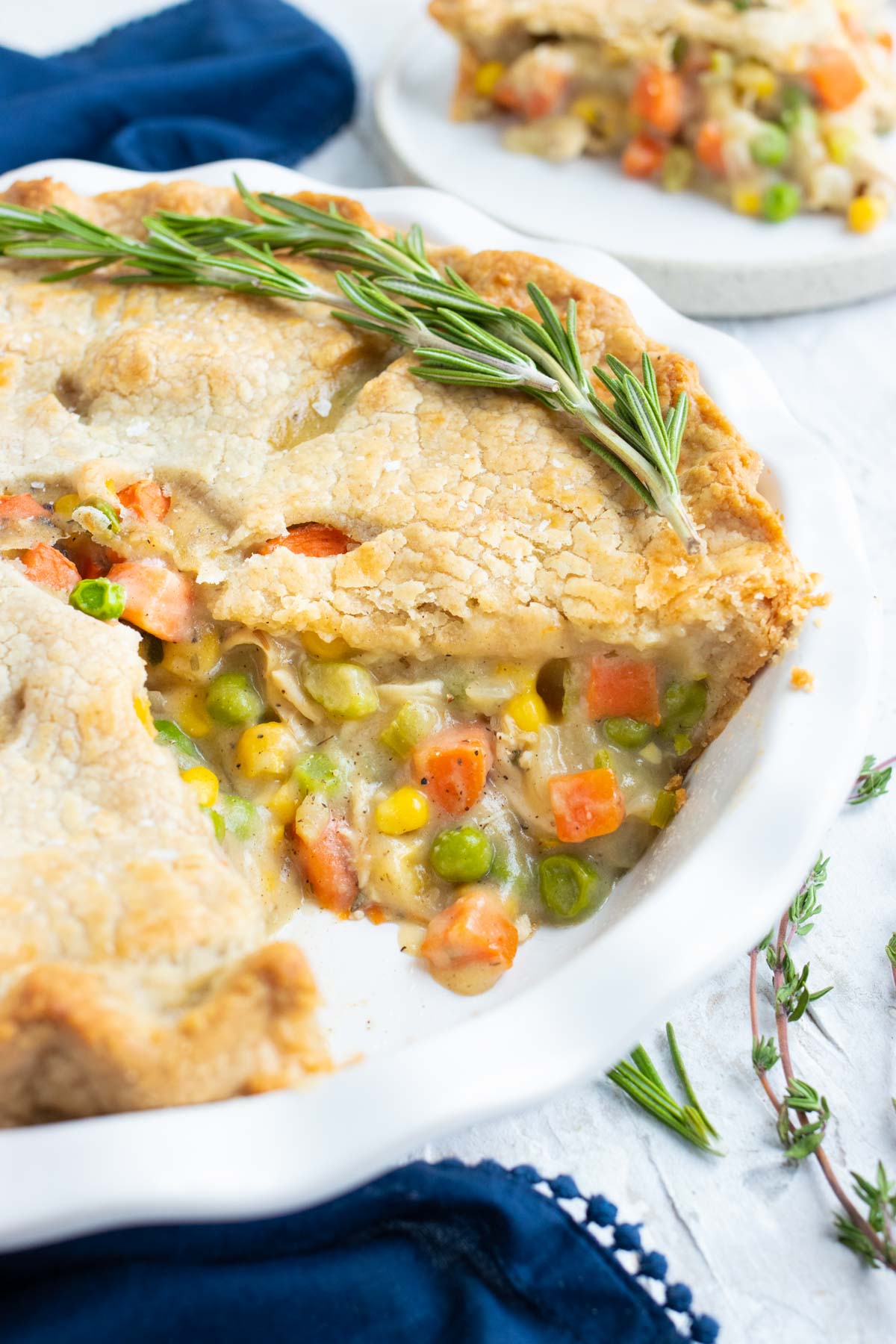 Homemade chicken pot pie recipe in a white baking dish for a comforting dinner.