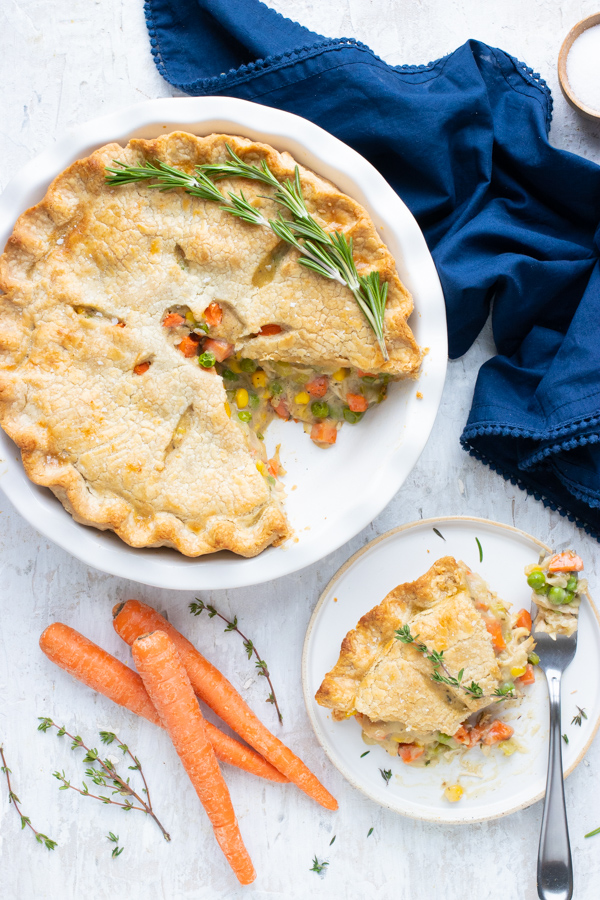 A whole pot pie is shown with a serving taken out on a plate.