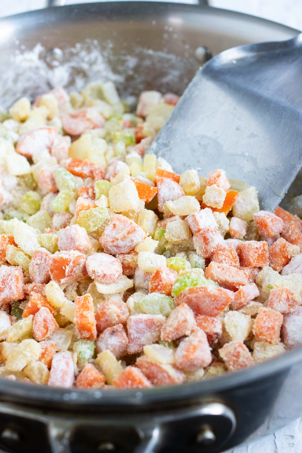 Flour is added to the sautéed vegetables.