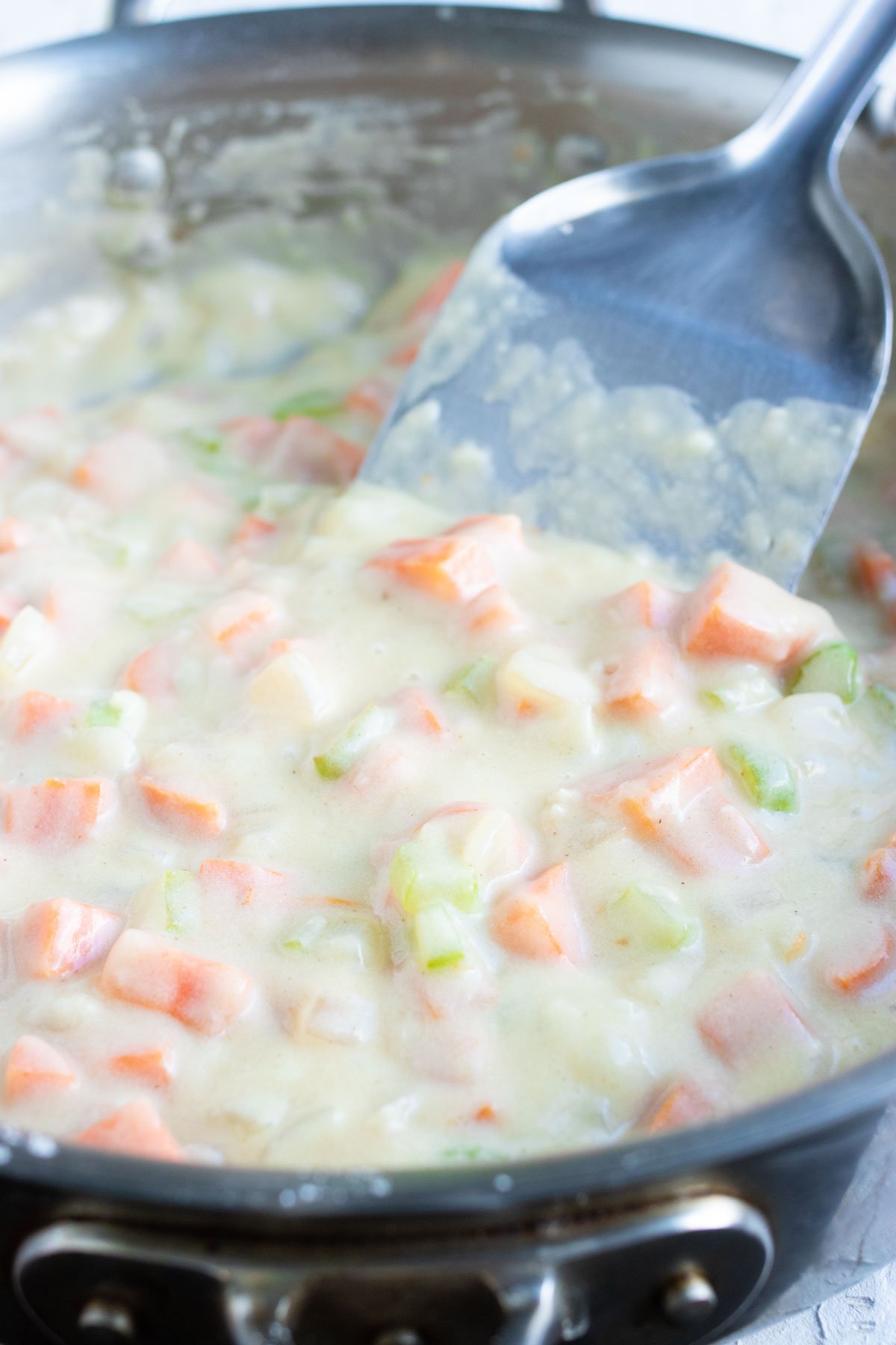 Broth and milk are added to the pan.