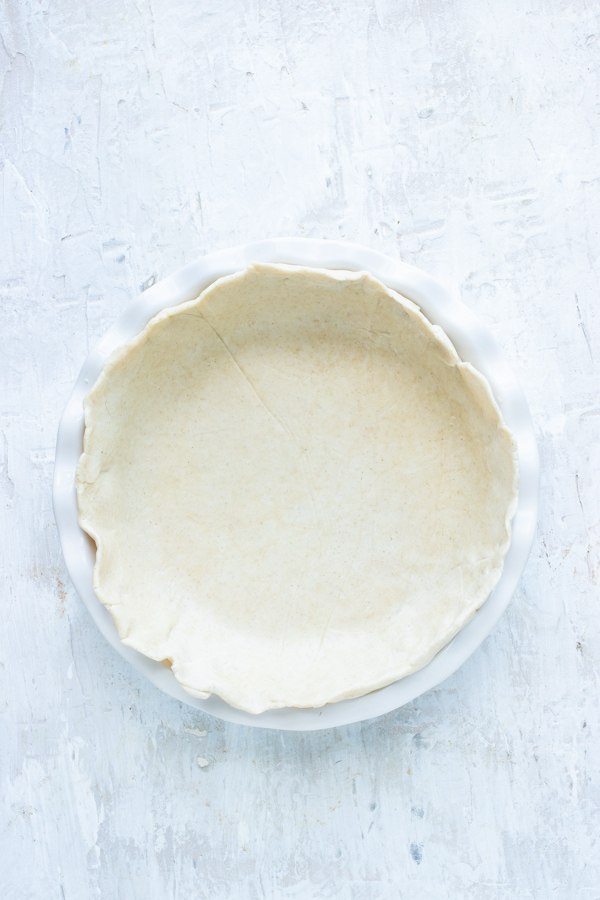 Pie crust is pressed into a pie pan.