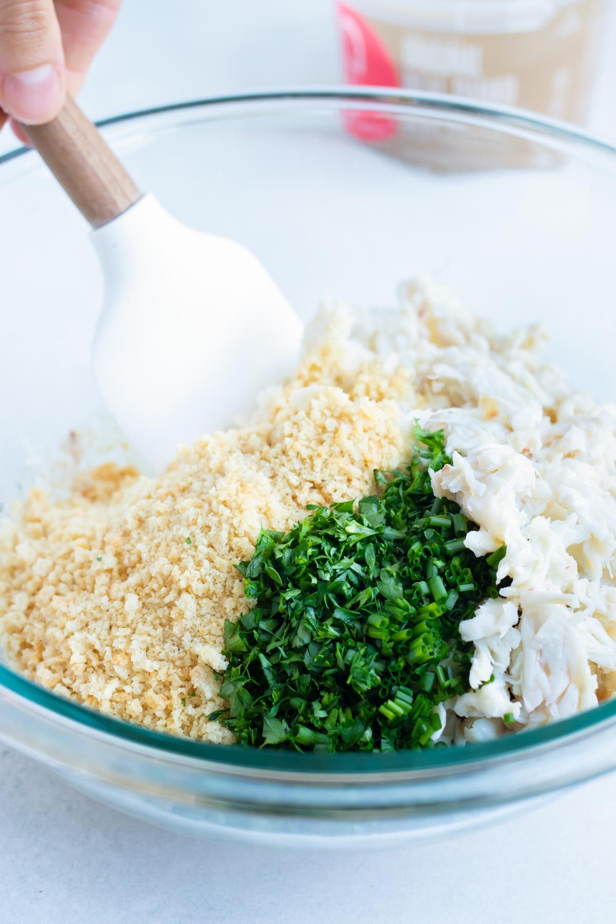 Crab meat, breadcrumbs, and chives are combined into the wet ingredients.
