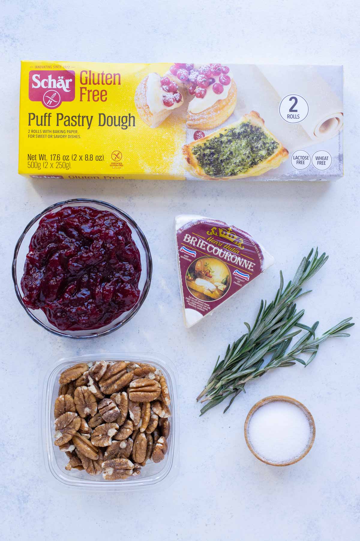 Puff pastry, cranberry sauce, brie cheese, pecans, rosemary, and salt are the ingredients in this recipe.