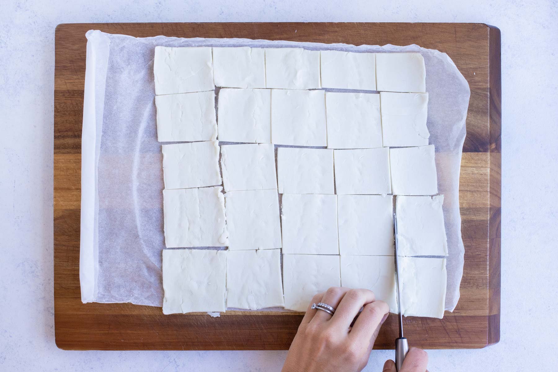 Puff pastry is cut into squares.