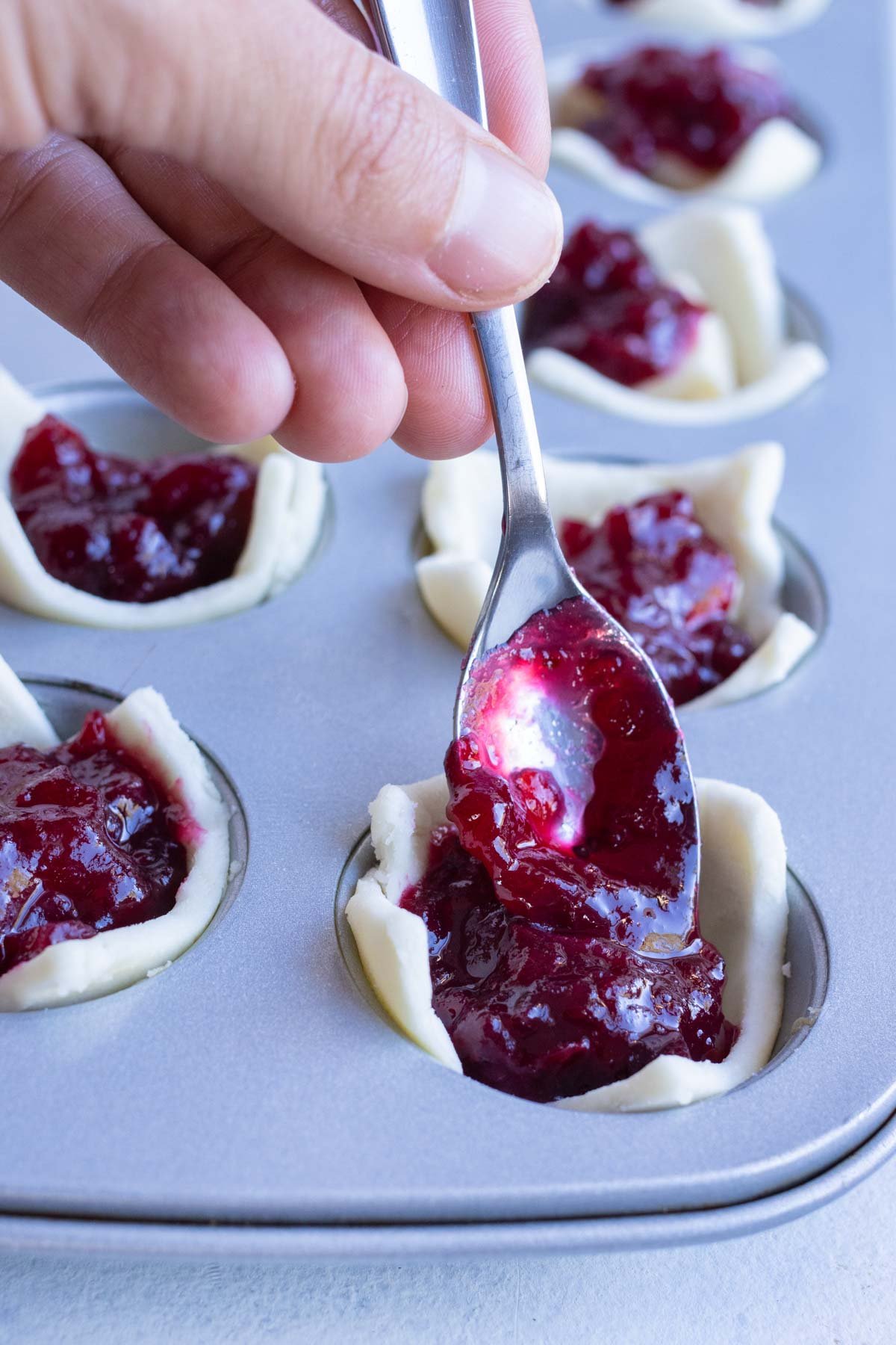 Homemade cranberry sauce is added to the puff pastry bites.