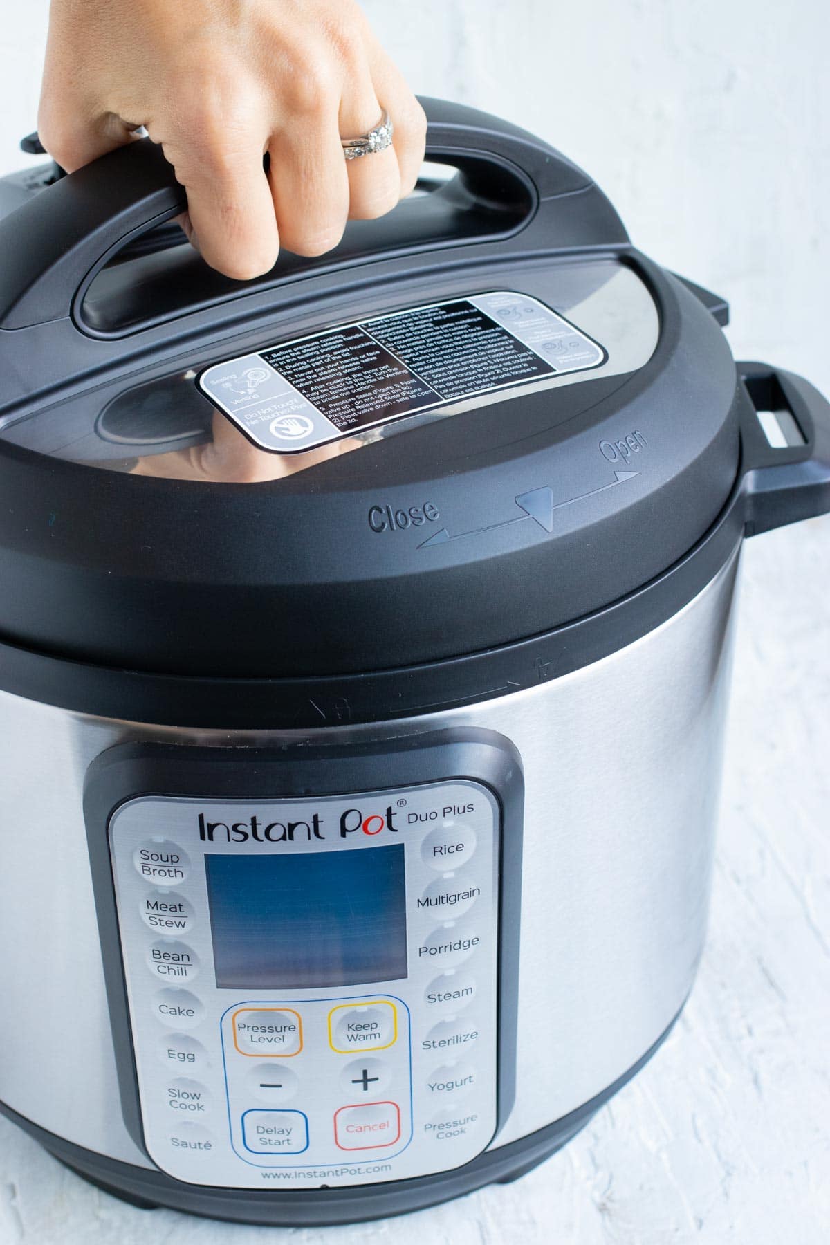 Demonstrating how to remove and put on the lid so it is tightly secured on an Instant Pot.