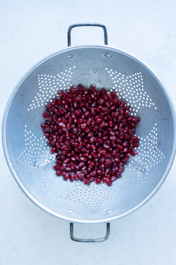 The seeds are drained from the water in a colander.