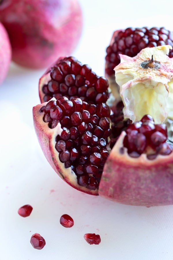 A pomegranate is cut open to remove the seeds.