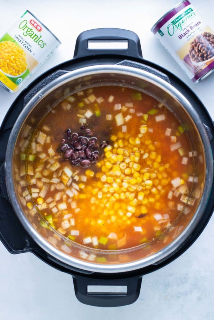 Black beans and whole kernel corn added to the pot for Instant Pot chicken tortilla soup with salsa.