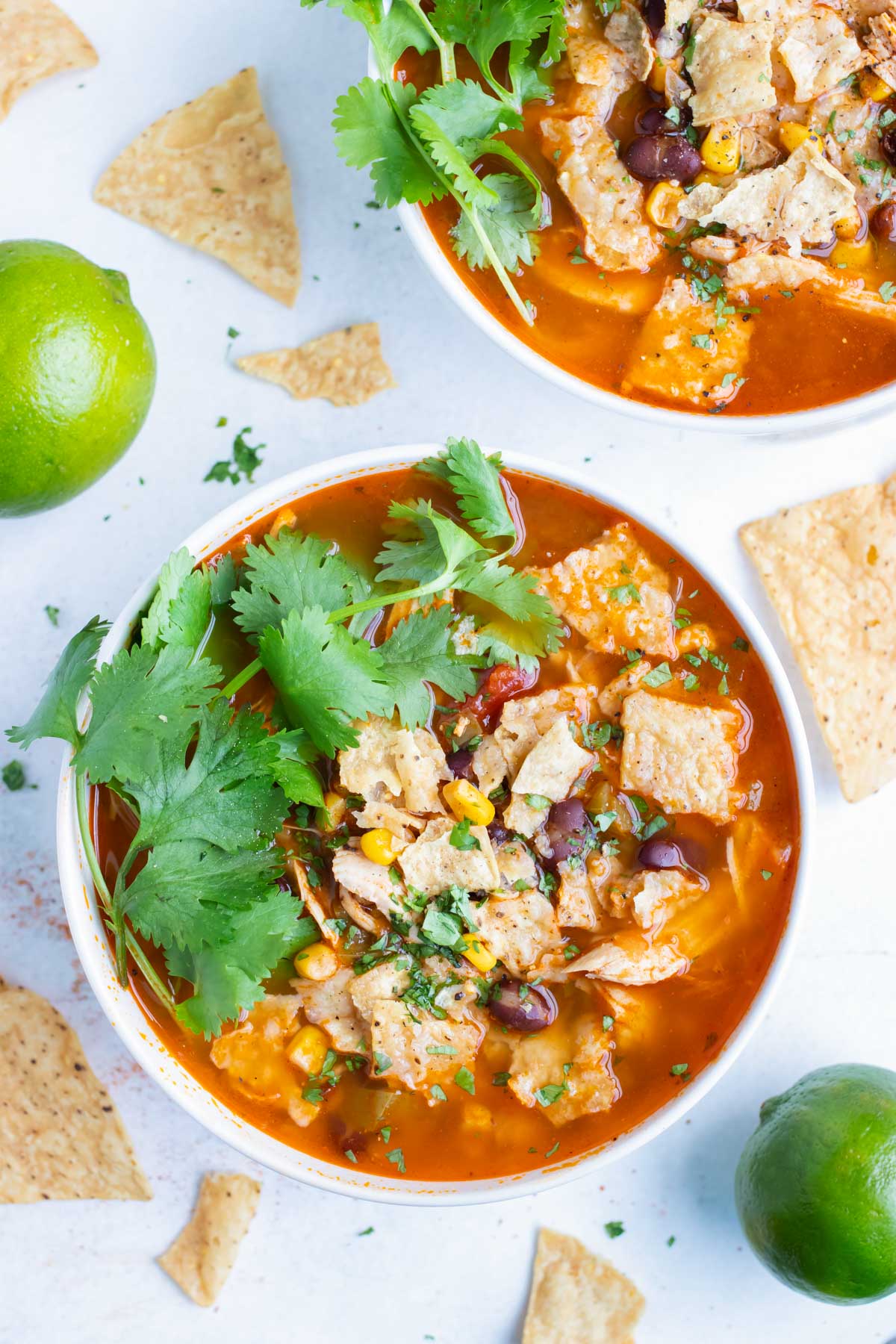 Chicken tortilla soup is topped with cilantro and served in a bowl.